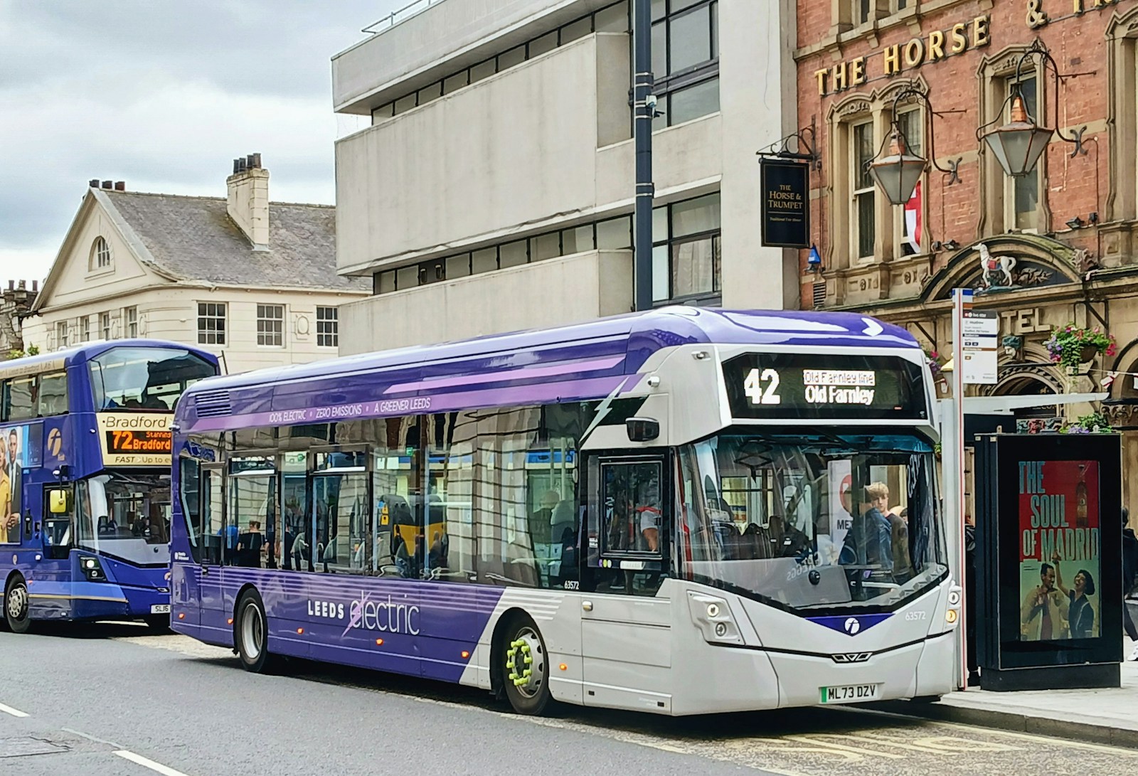 A couple of buses that are sitting in the street
